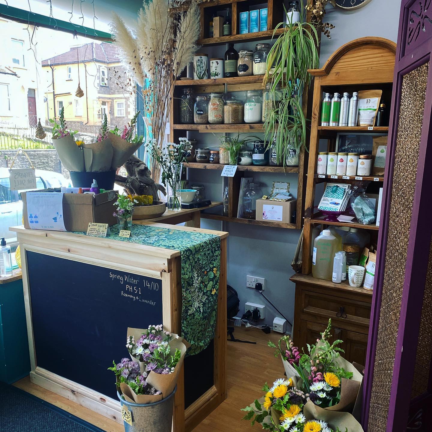 A photograph of a counter with various hand-made hair products \x26 plants.